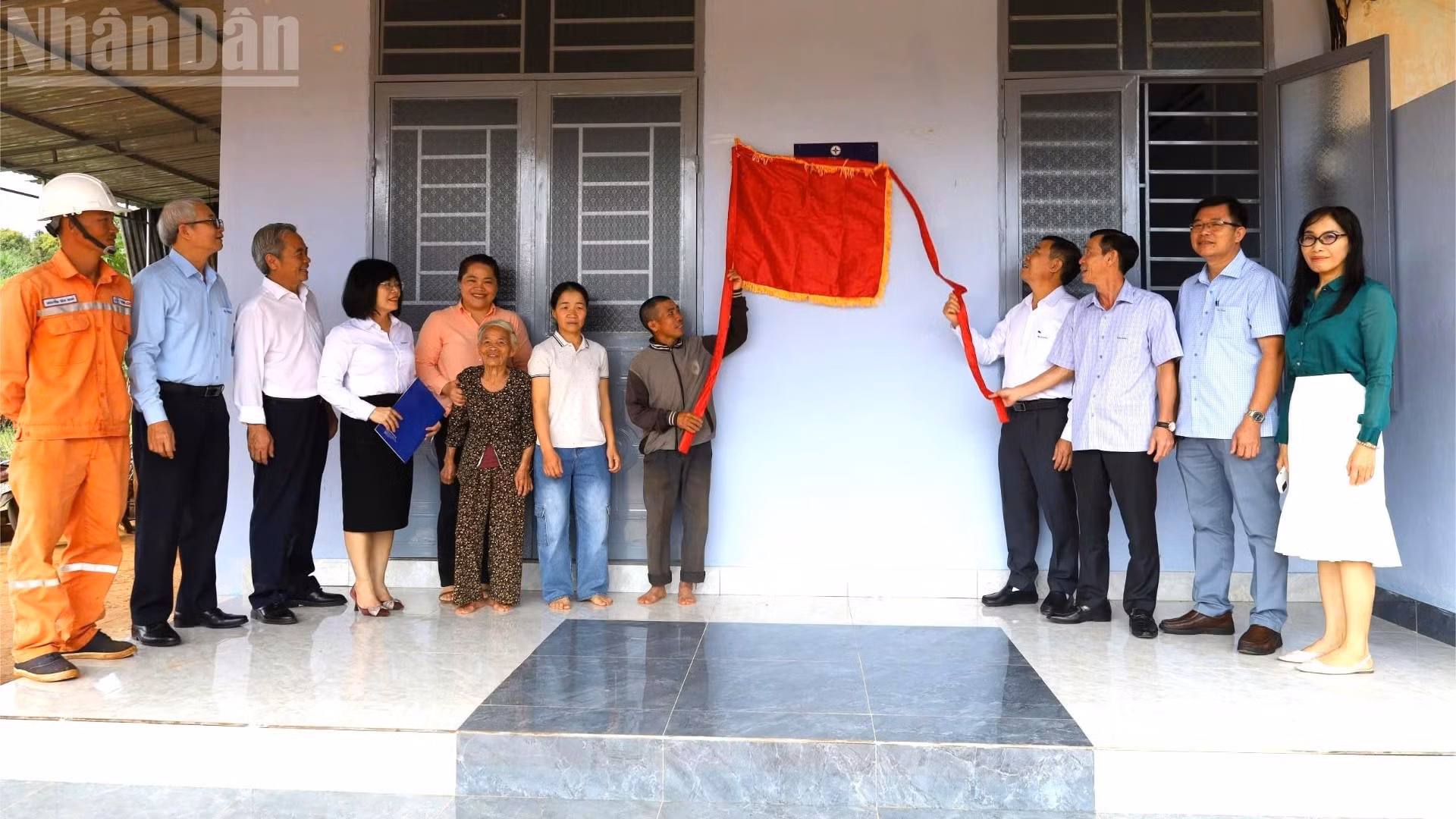 Участники церемонии вместе с семьей Нгуен Хыу Зунга перерезают ленту на открытии нового дома.