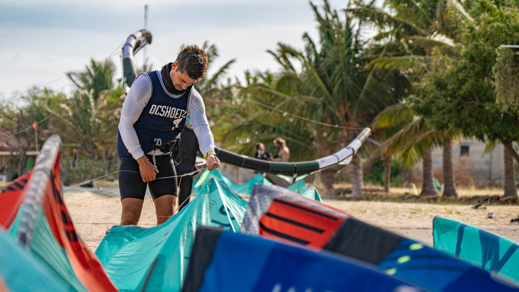 Спортсмен накачивает свой кайт.
