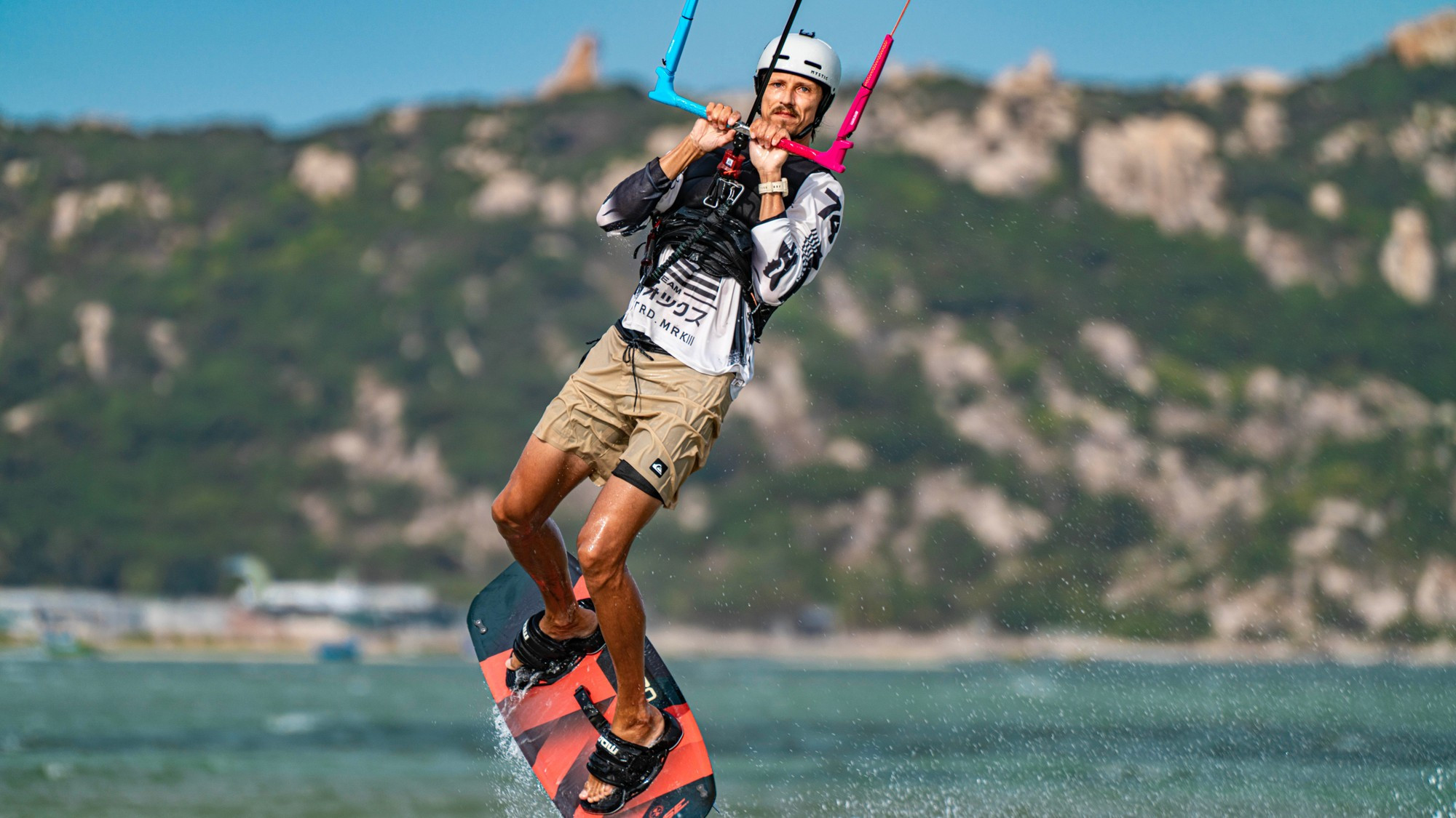 Мгновение, когда ветер подхватывает спортсмена и поднимает его высоко над водой.