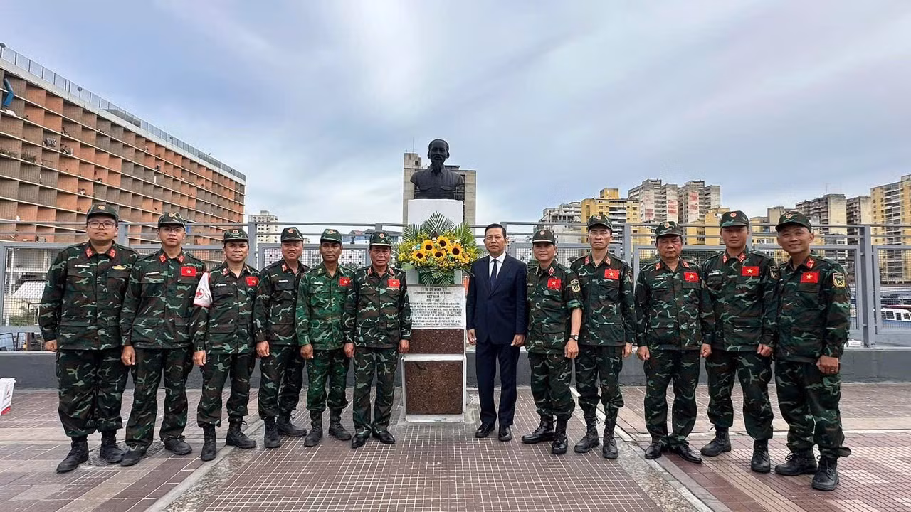 Посол Ву Чунг Ми, заместитель начальника Управления поисково-спасательных работ Генерального штаба Вьетнамской народной армии генерал-майор Фам Ван Ти, возглавляющий миссию, и военнослужащие – члены спасательной миссии Вьетнама фотографируются на память у памятника Президенту Хо Ши Мину. (Фото: Посольство Вьетнама в Венесуэле)