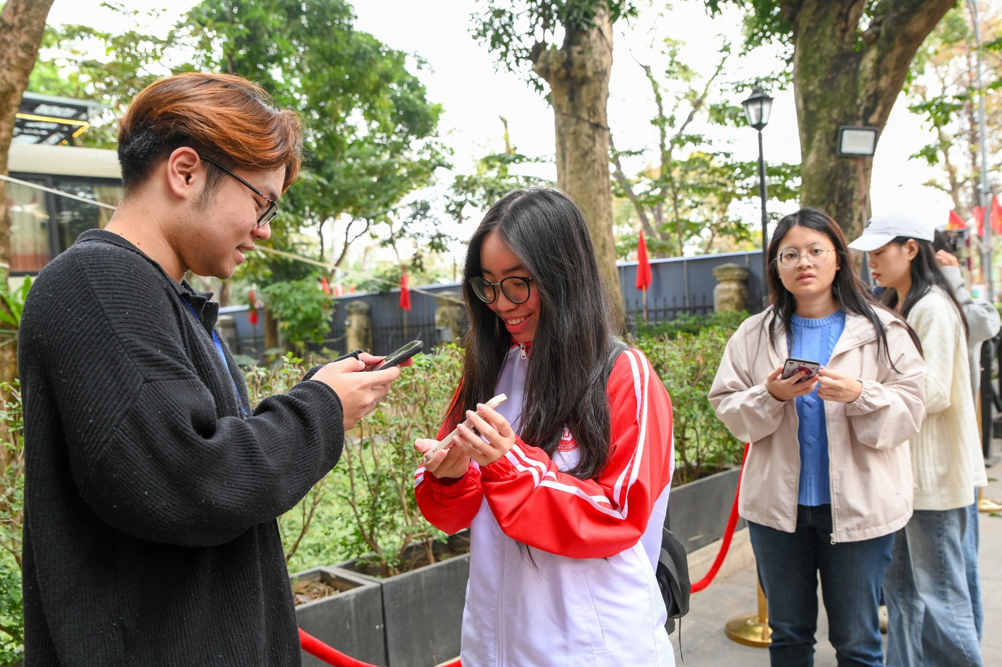 Молодые люди с радостью ожидают своей очереди для получения билетов.