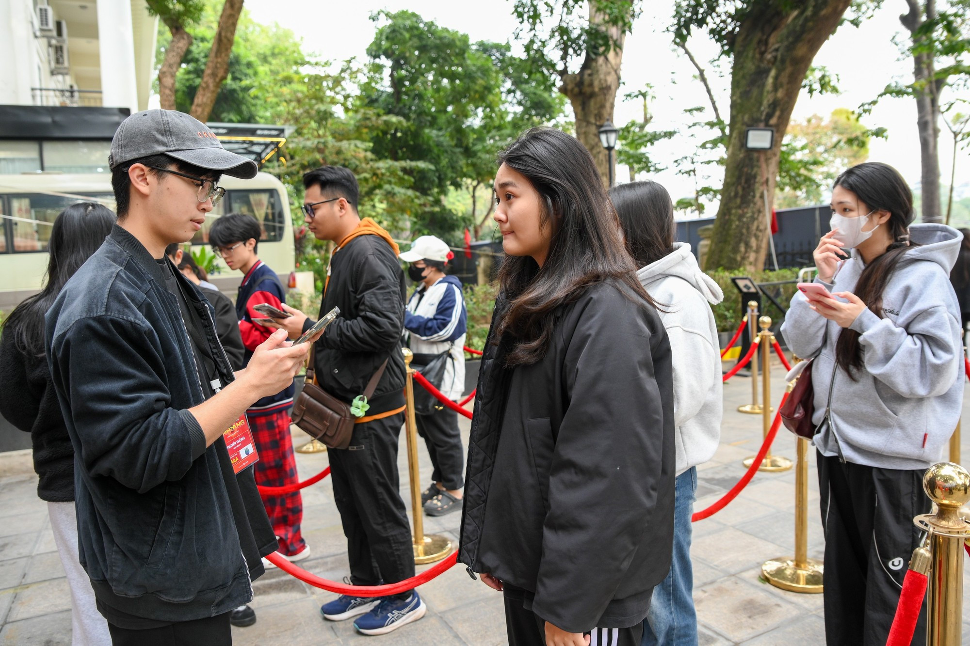 Молодые люди выстраиваются в очередь для сканирования QR-кодов с целью получения билетов на программу.