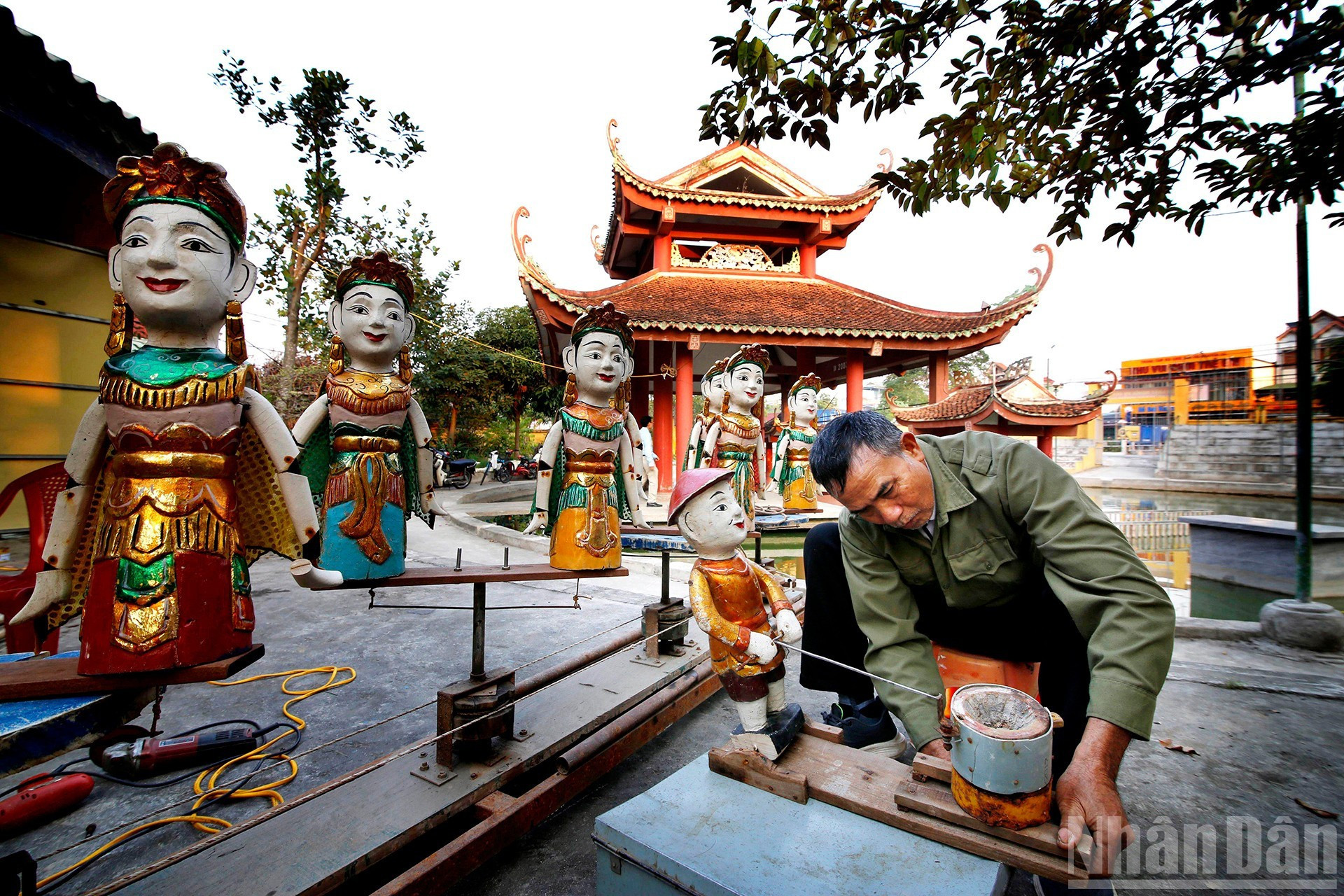 Заслуженный мастер Нгуен Тят Луан проверяет куклы.