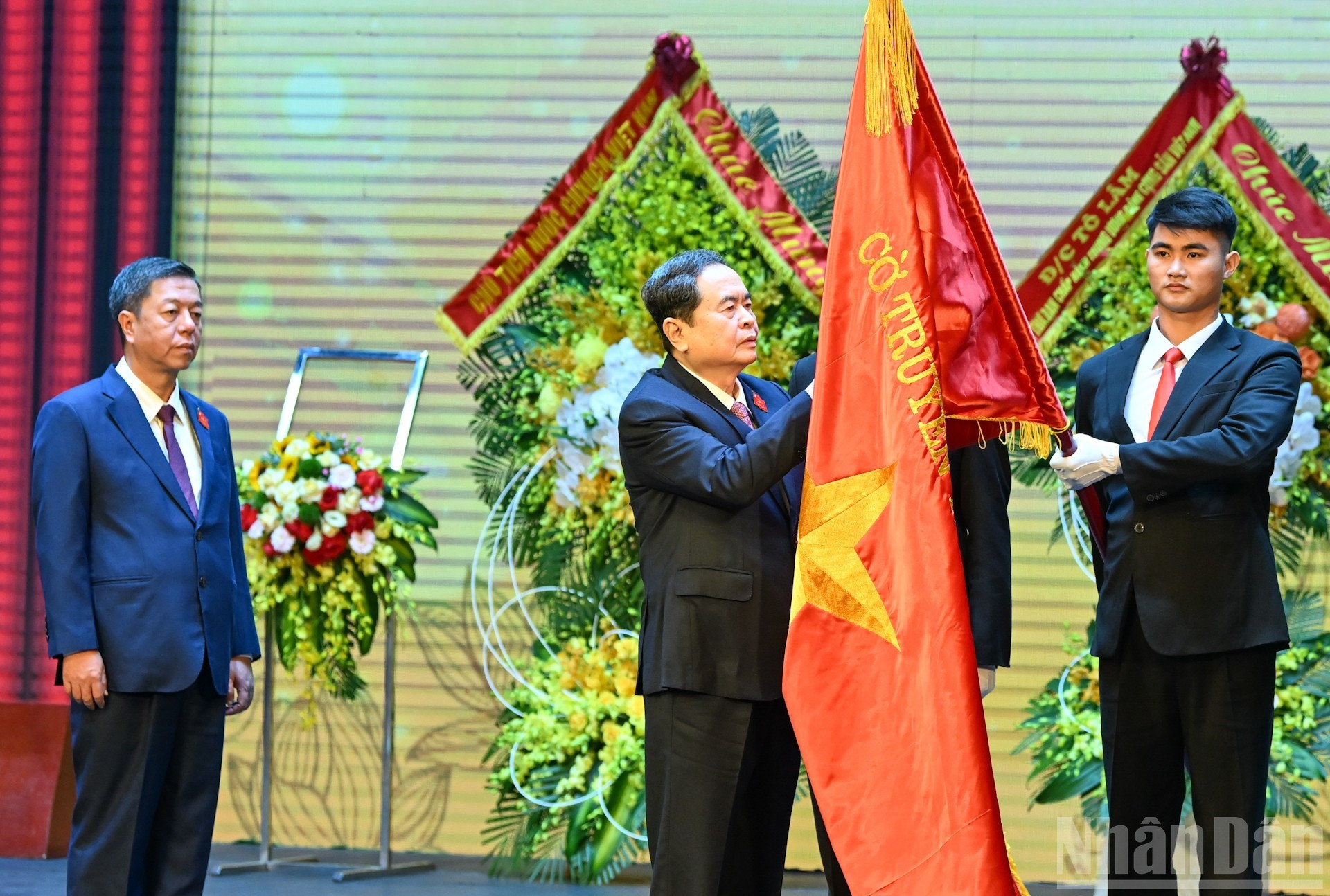 Председатель НС Чан Тхань Ман прикрепляет Орден Труда первой степени к традиционному знамени Государственного политического издательства «Правда».