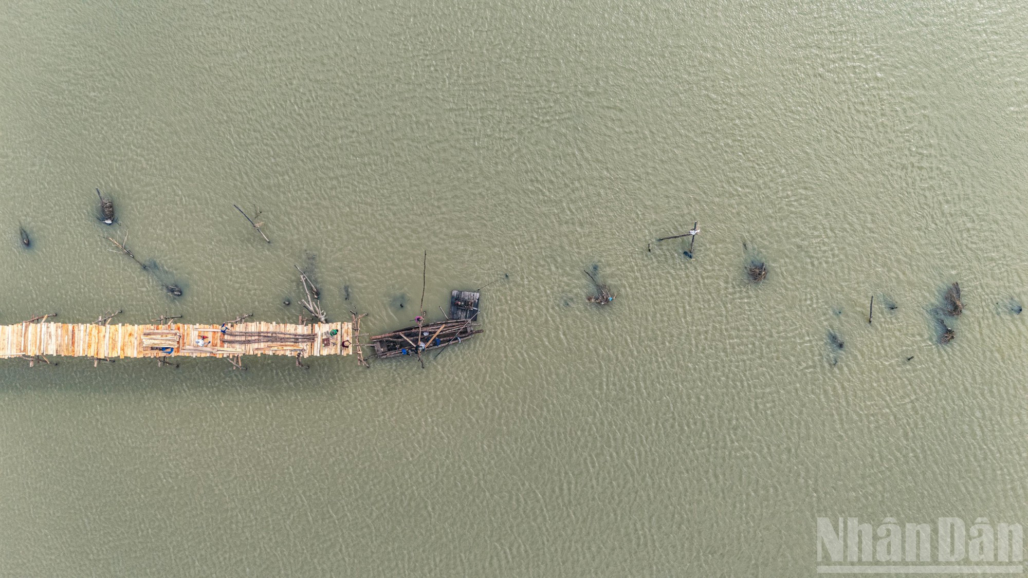 Работы ведутся слаженно прямо посреди реки Биньба, которая после разрушительных паводков вновь обрела спокойствие.