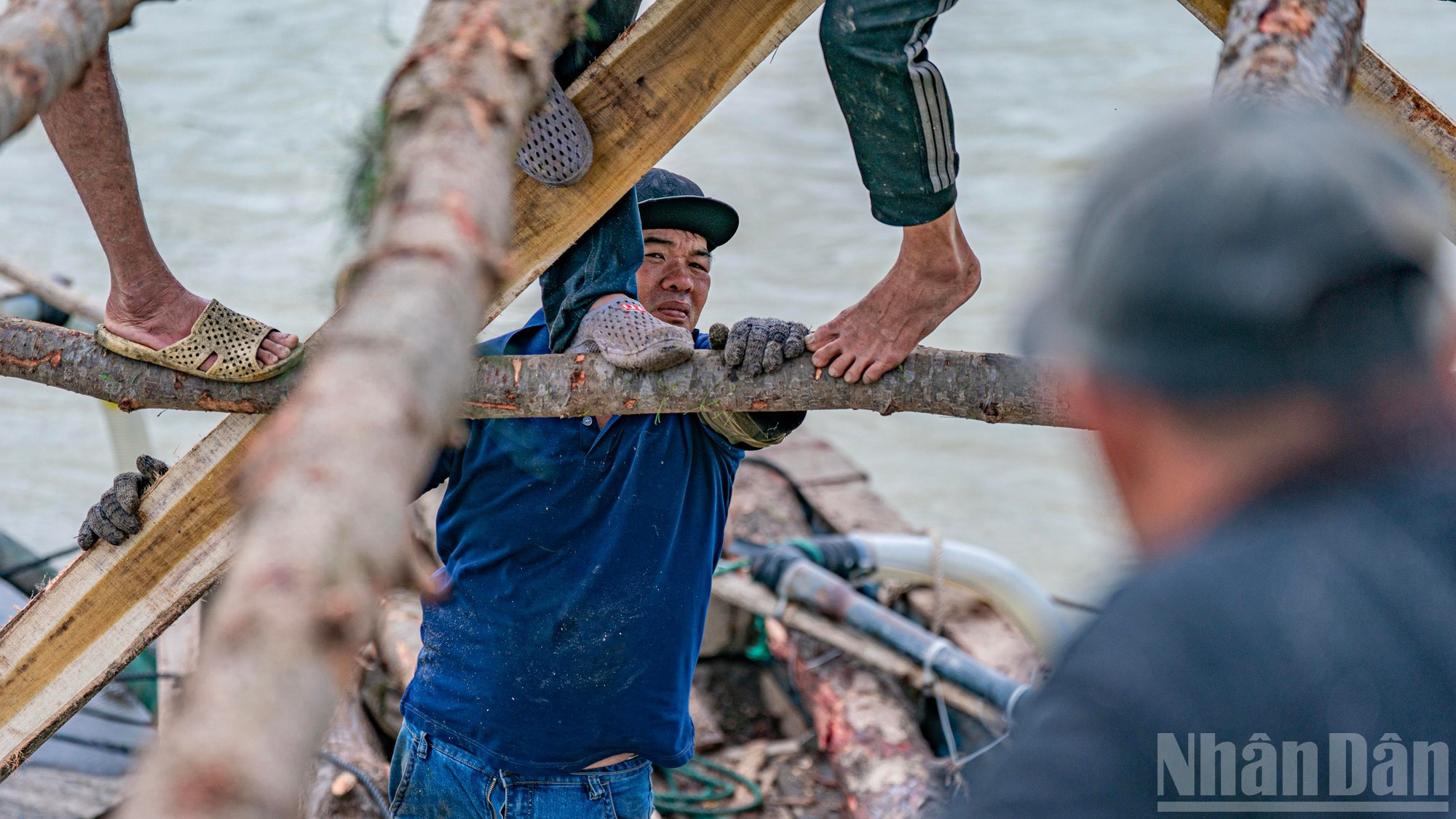 Лодочник, внимательно прислушиваясь к указаниям, одновременно голыми руками удерживает лодку, фиксируя ее у только что установленного пролета.