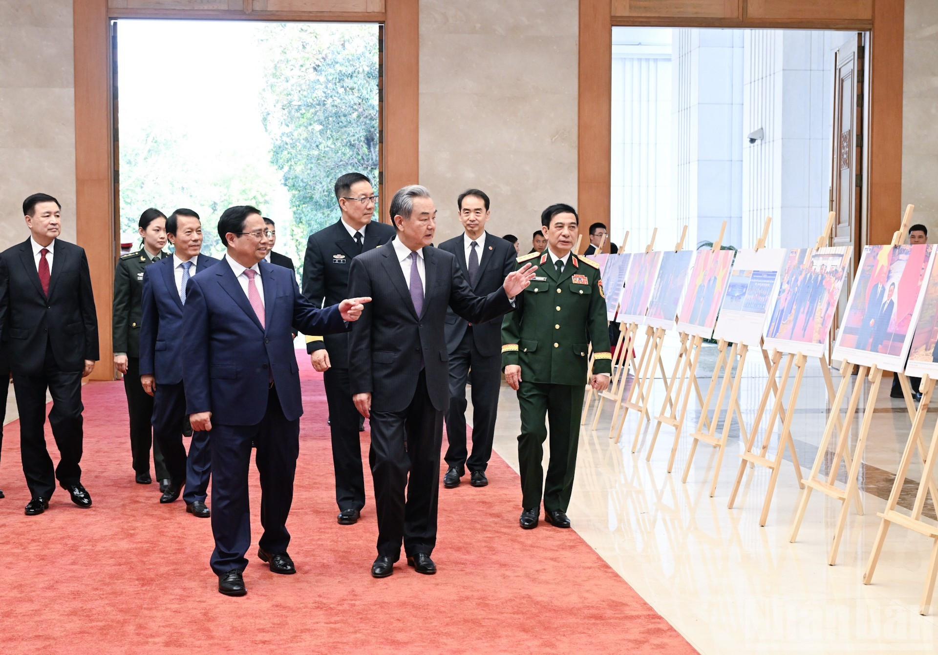 Премьер-министр Фам Минь Тьинь и Министр иностранных дел Китая Ван И вместе с членами делегации осматривают фотоматериалы о сотрудничестве двух стран.