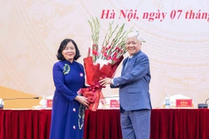 Постоянный замсекретаря Парткома НС, бывший Председатель ЦК ОФВ До Ван Тьиен вручает цветы с поздравлением товарищу Буй Тхи Минь Хоай.