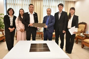 Председатель Государственного комитета по делам вьетнамцев, проживающих за границей, Нгуен Чунг Киен вручает бронзовую мемориальную доску представителю сообщества вьетнамцев в Вануату До Ван Зы. 