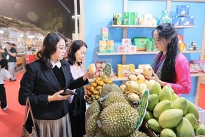 Посетители приобретают продукцию на фестивале Vietnam OCOP 2025, одном из ключевых национальных программ по продвижению торговли. Фото: ВИА