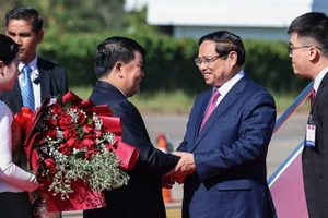 Должностные лица Лаоса приветствуют Премьер-министра Фам Минь Тьиня. Фото: VGP