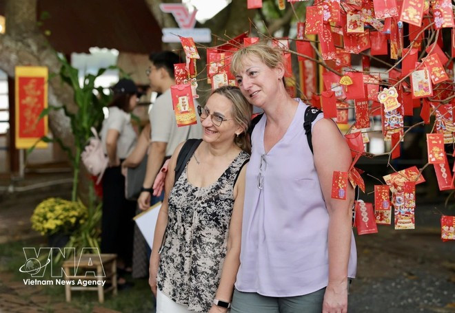 Иностранные туристы делают «check-in» в пространстве вьетнамского Тэта в городе Хошимин. Фото: ВИА