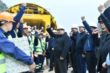 Премьер-министр Фам Минь Тьинь вместе с инженерами и рабочими. Фото: Тхань Жанг