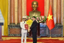 Президент Лыонг Кыонг вручает товарищу Ле Куок Хунгу решение о присвоении воинского звания генерал-полковника.