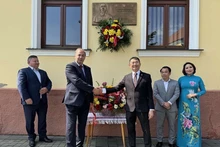 Делегаты перед бронзовой мемориальной доской в память о визите Президента Хо Ши Мина. Фото: baoquocte.vn