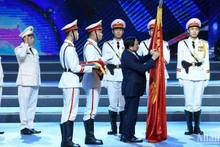 Премьер-министр Фам Минь Тьинь вручает значок о присвоении звания «Герой Народных вооруженных сил». Фото: Чан Хай