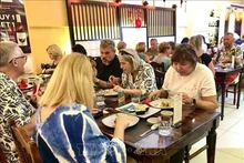 Иностранные гости наслаждаются традиционными блюдами Тэт. Фото: ВИA