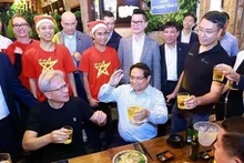 Премьер-министр Фам Мин Тьинь и Генеральный директор NVIDIA Дженсен Хуан наслаждаются уличной едой в Ханое, 5 декабря 2024 года. Фото: ВИA