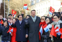 Премьер-министры двух стран фотографируются с представителями вьетнамской общины в Люксембурге. Фото: VGP