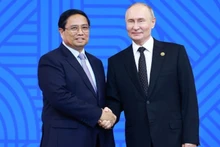 Президент России Владимир Путин (справа), Председатель БРИКС 2024, приветствует Премьер-министра Фам Минь Тьиня. Фото: ВИA