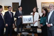 Президент Вьетнама Лыонг Кыонг (третий слева) дарит фотографию сенатору Исабель Альенде, дочери покойного Президента Чили. Фото: ВИА