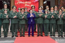 Премьер-министр Фам Минь Тьинь и кадровые работники, преподаватели Военного университета культуры и искусств. Фото: Чан Хай