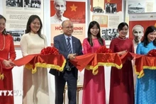 Посол Вьетнама во Франции Динь Тоан Тхань (третий слева) и другие делегаты перерезают ленточку на открытии выставки.