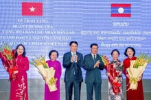 Президент Лыонг Кыонг и Генеральный секретарь ЦК НРПЛ, Президент Лаоса Тхонглун Сисулит дарят цветы действующим и бывшим Вице-президентам Вьетнама.