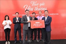 Представитель Viettel Global Као Мань Дык символически вручает 300 подарков председателю Кхмерско-вьетнамского общества. Фото: ВИА 