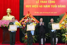 Товарищ Во Ван Тхыонг вручает знаки «40 лет членства в КПВ» товарищам Фан Ван Жангу, Хоанг Суан Тьиену и Ле Хюи Виню. Фото: qdnd.vn