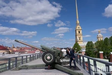 Председатель Общества вьетнамцев в России До Суан Хоанг стреляет из пушки в Петропавловской крепости. Фото: Тхань Тхэ