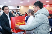 Премьер-министр Фам Минь Тьинь вручает подарки трудящимся, находящимся в трудной ситуации, в компании Kefico при корпорации Hyundai Motor в провинции Хайзыонг, 10 января. Фото: VGP