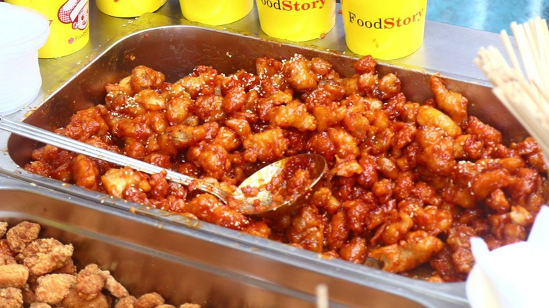 Корейский павильон предложил гостям курицу в сладком соусе. Нежные кусочки курицы были приготовлены с фирменным сладким соусом, который придавал блюду мягкий карамельный оттенок и лёгкую пикантность. Посетители с интересом пробовали это популярное блюдо корейской кухни.