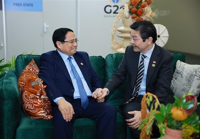 Премьер-министр Фам Минь Тьинь встречается с премьер-министром Сингапура Лоренсом Вонгом. (Фото: ВИА)