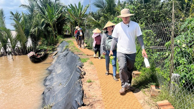 Туристы испытывают прогулку по дорожке, выстеленной ковром из кокосового волокна.