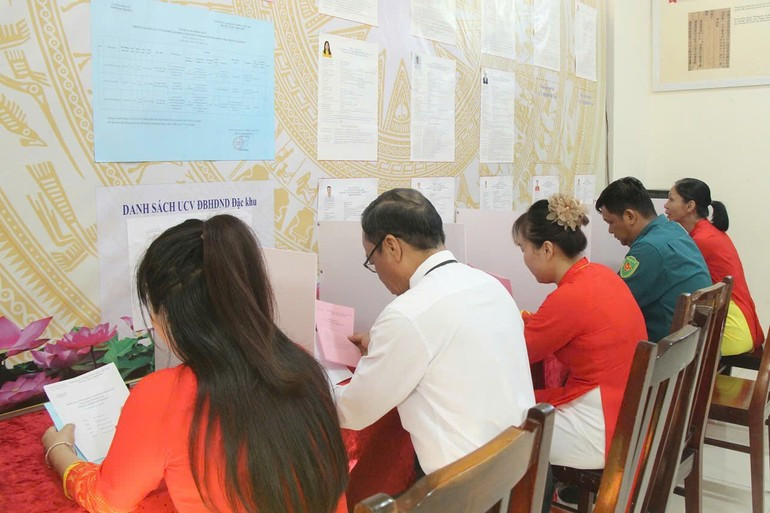 Избиратели получают бюллетени для голосования.