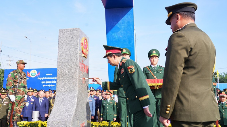 Генерал армии Тиа Сеиа, заместитель премьер-министра, министр национальной обороны Королевства Камбоджа, наблюдает, как генерал армии Фан Ван Жанг, министр национальной обороны Вьетнама, наносит краску на пограничный столб №171 в международном пункте пропуска Мокбай (провинция Тэйнинь). (Фото: ВИА)