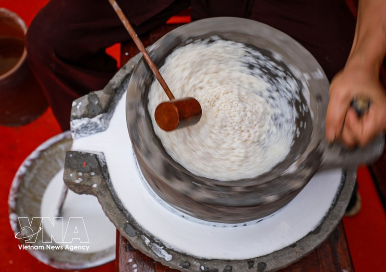 Процесс помола риса с использованием традиционной каменной мельницы. (Фото: ВИА)