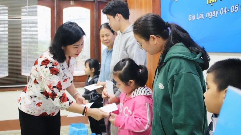 Товарищ Нгуен Тхи Туен, Заместитель председателя Центрального комитета Отечественного фронта Вьетнама, Председатель Союза женщин Вьетнама, вручает подарки детям, находящимся в трудной жизненной ситуации.