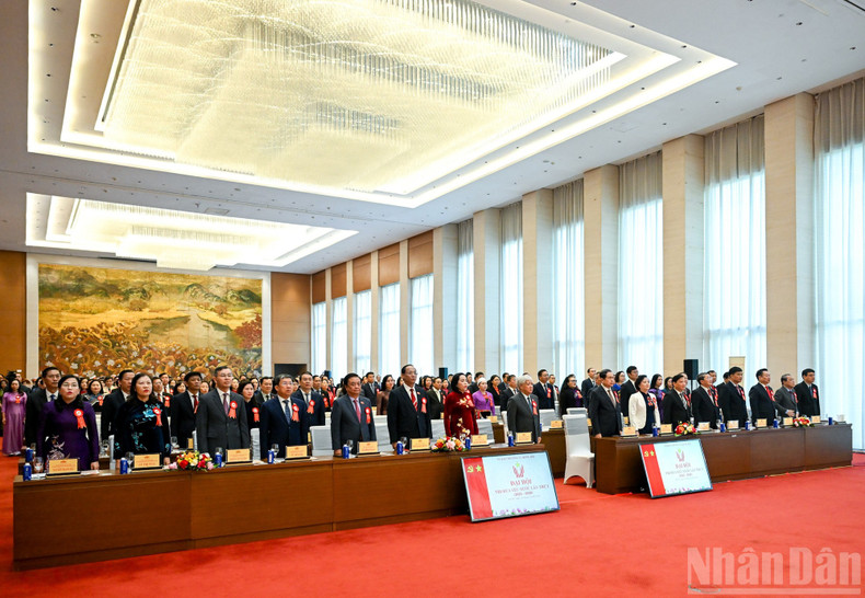 Руководители Партии, Государства и делегаты выполняют ритуал приветствия флага.