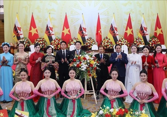 Президент Лыонг Кыонг, Премьер-министр Фам Минь Тьинь вместе с Султаном Брунея-Даруссалама Хаджи Хассаналом Болкиахом и принцем Брунея Абдулом Матином позируют с вьетнамскими артистами. (Фото: ВИА)