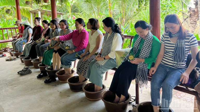 Туристы расслабляются, погружая ноги в травяной лечебный раствор, приготовленный местными жителями.