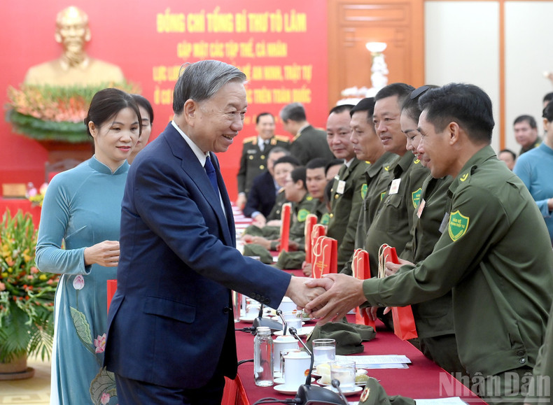 Генеральный секретарь ЦК КПВ То Лам вручает подарки делегатам на встрече.