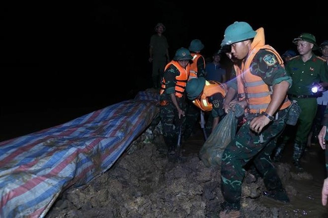 Силы гражданской обороны и военные подразделения продолжают наращивать земляные укрепления, предотвращая перелив воды и обеспечивая безопасность дамбы реки Кау. (Фото: ВИА) Силы гражданской обороны и военные подразделения продолжают наращивать земляные укрепления, предотвращая перелив воды и обеспечивая безопасность дамбы реки Кау. (Фото: ВИА)