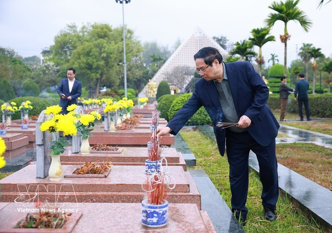 Премьер-министр Фам Минь Тьинь возлагает благовония и цветы, выражая глубокое уважение и бесконечную благодарность, почитая память павших героев на кладбище павших героев A1. (Фото: ВИА)