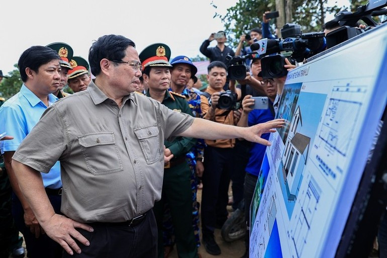 Премьер-министр Фам Минь Тьинь выслушивает отчет о проекте домов, устойчивых к наводнениям. (Фото: VGP)