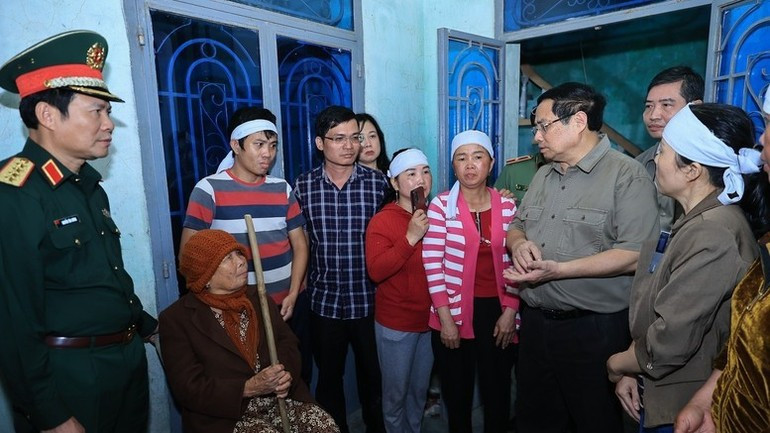 Премьер-министр Фам Минь Тьинь поддерживает семьи, у которых были погибшие в результате наводнений. (Фото: VGP)