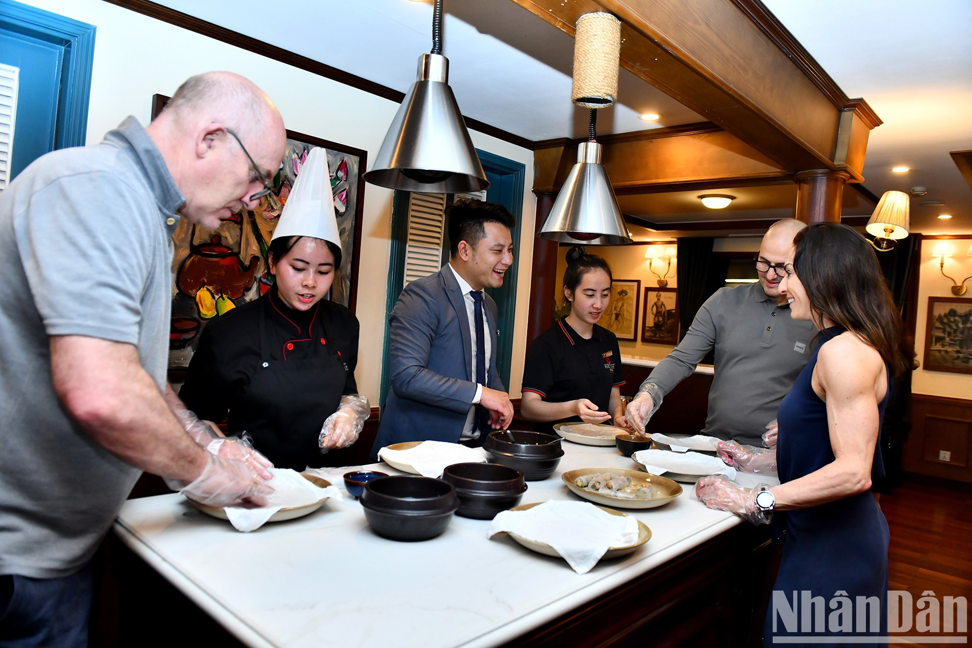 Посетители проходят мастер-класс по приготовлению роллов «нэмкуон» с поварами на борту. Посетители проходят мастер-класс по приготовлению роллов «нэмкуон» с поварами на борту.