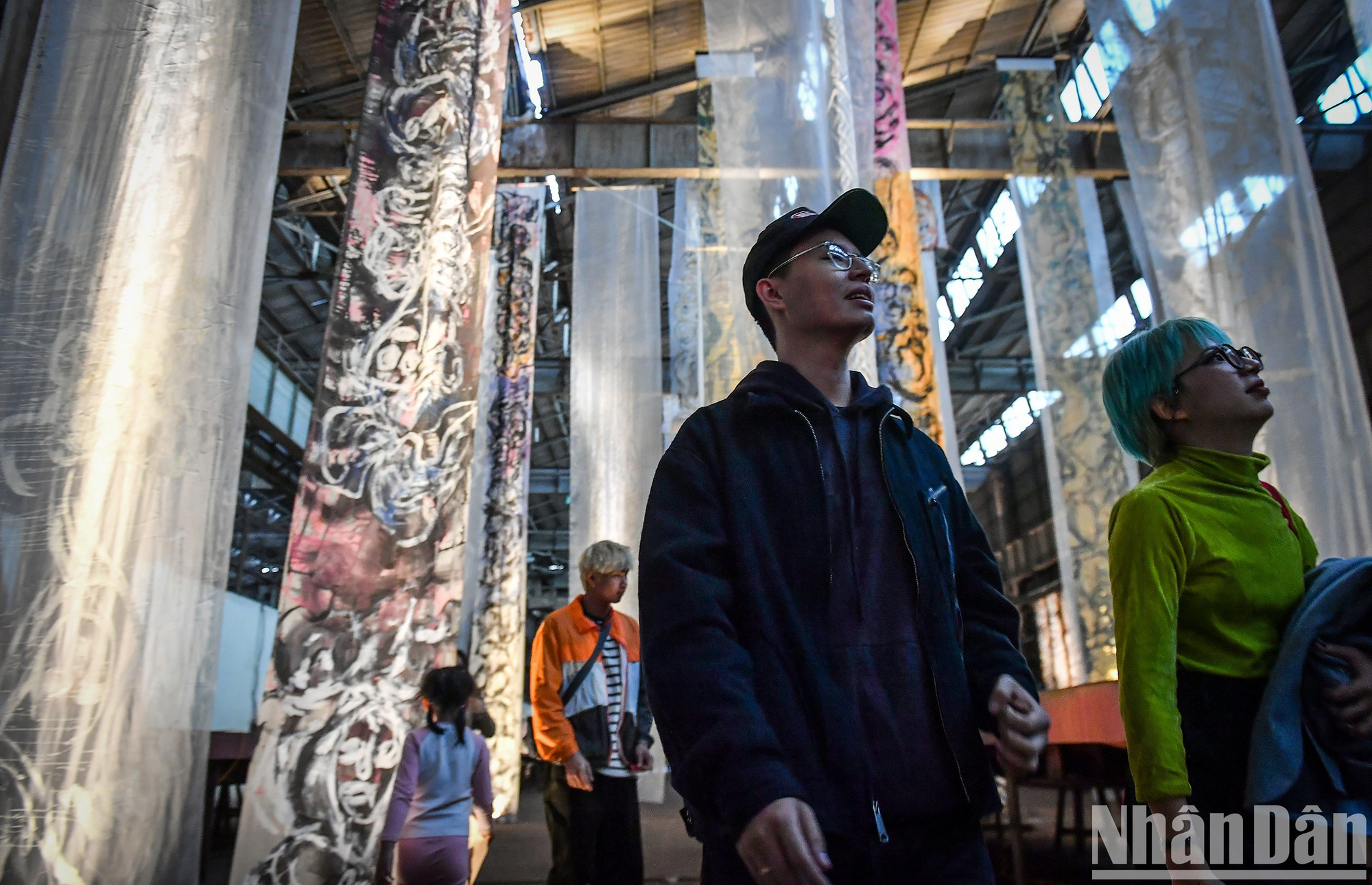 Выставка художественной инсталляции «Зов» художника Тху Чан с полосами картин длиной 40-60 метров, подвешенными на потолке мастерской 3Б1.