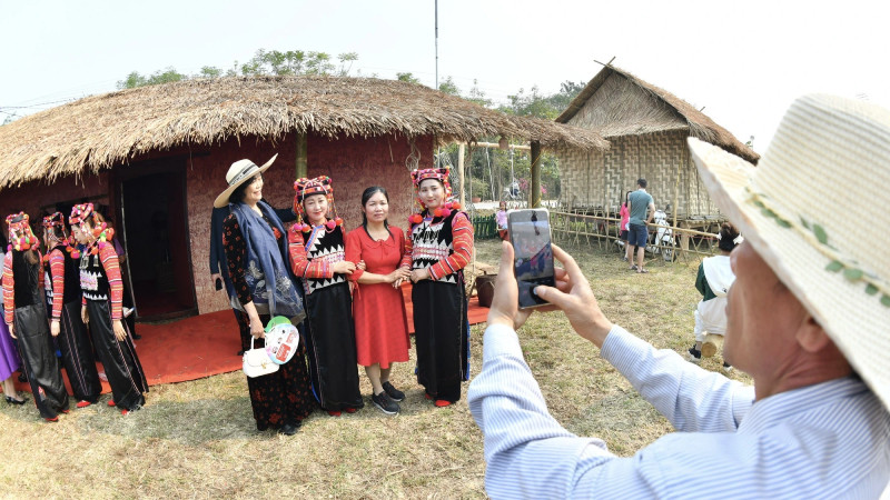 Туристы с восторгом фотографируются с женщинами народности Ханьи. Туристы с восторгом фотографируются с женщинами народности Ханьи.